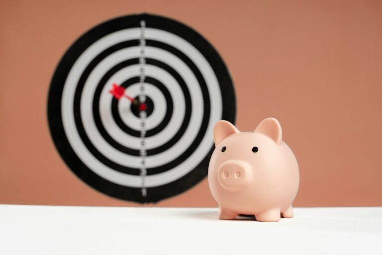 A piggy bank in front of a dartboard symbolizing financial goals and smart savings.
